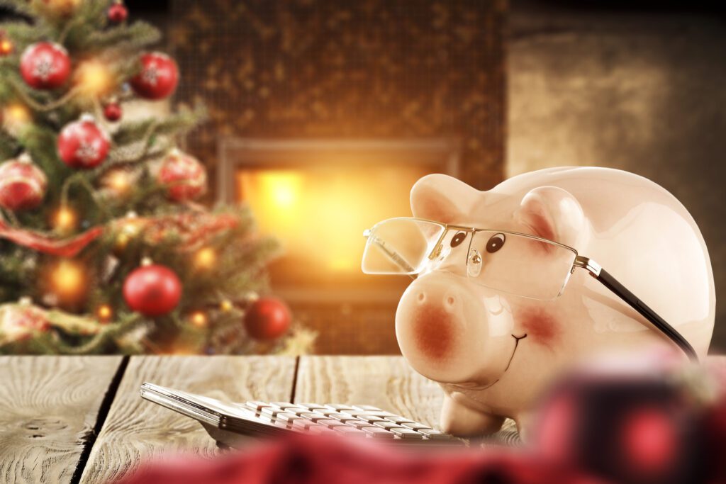 A piggy bank using a calculator by a christmas tree for Splash Tears Dry Eye Drops blog